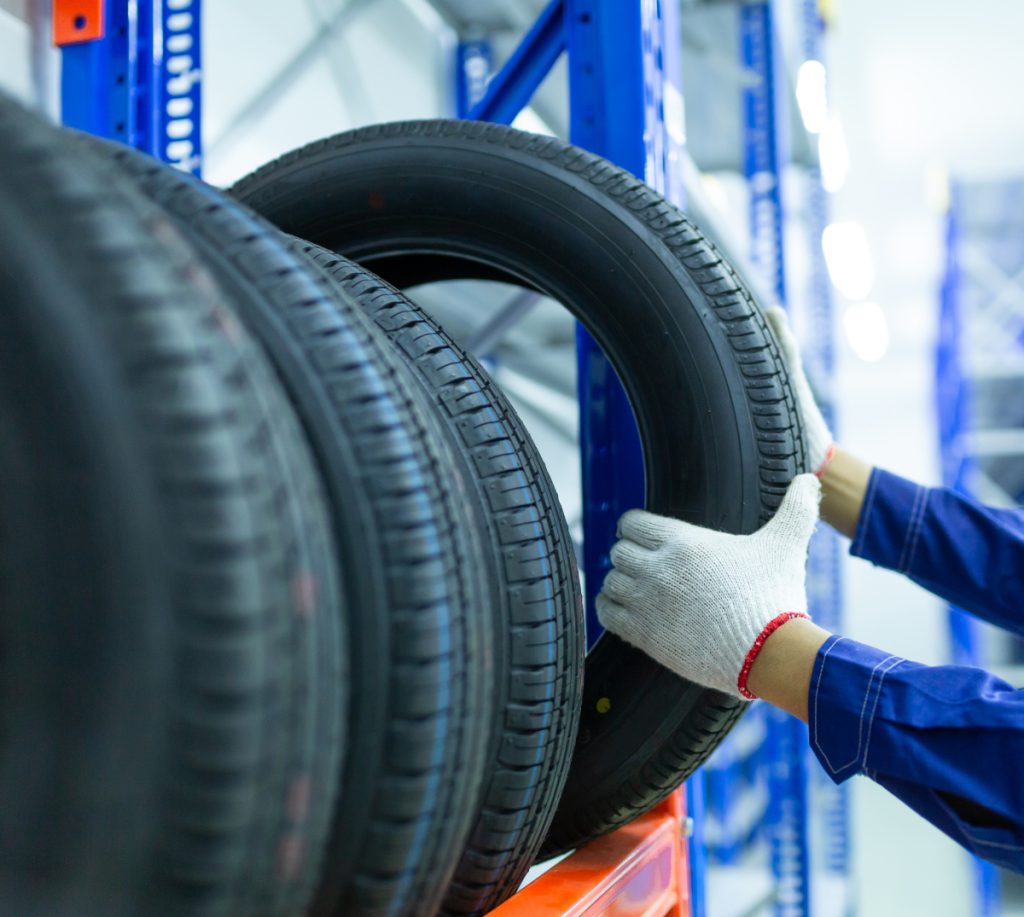 Mechanic picking up a tyre from stock - Tyres Stockport | Professional Tyre Fitting & Vehicle Services